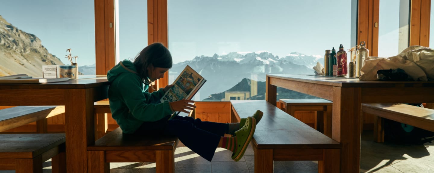 enfant qui lit avec les montagnes